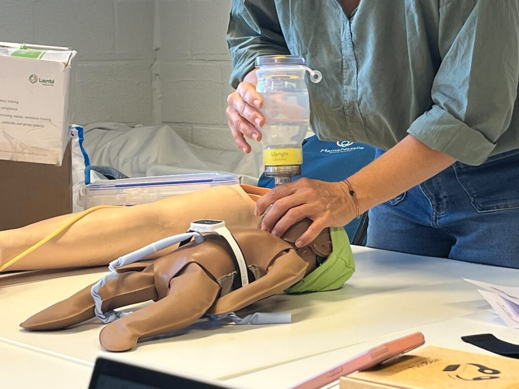 Ballon de réanimation Upright de Laerdal tenu à la verticale au-dessus d’un mannequin de nouveau-né.