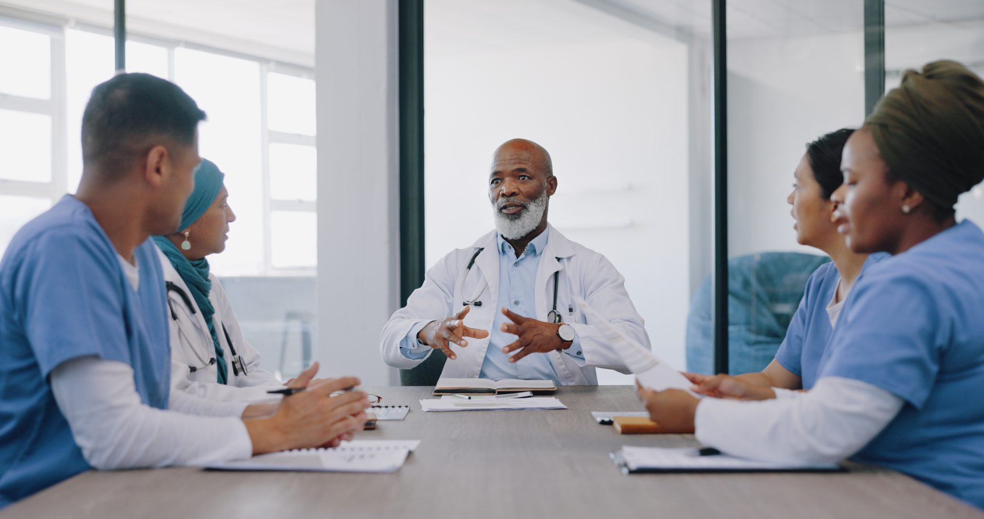 Réunion de travail entre médecins et infirmiers autour d’une table