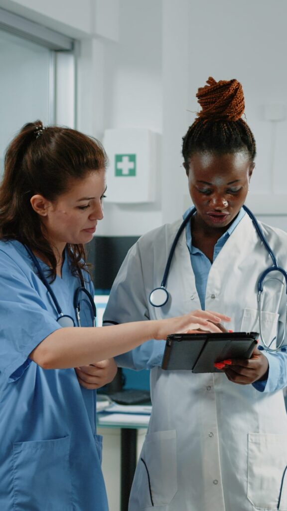 Une médecin et une infirmière consultent ensemble des données sur une tablette